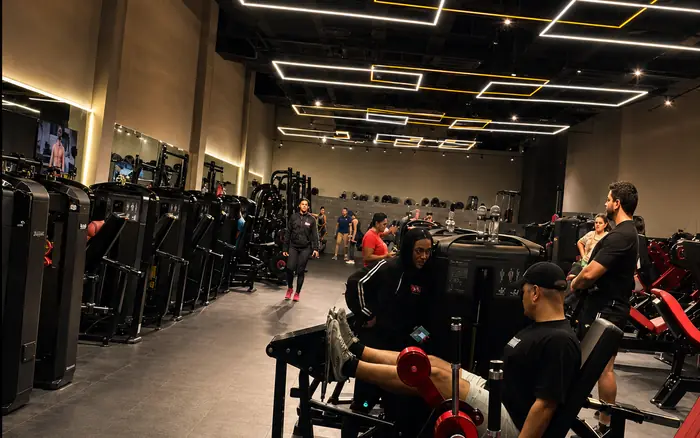 Área de aparelhos da Dubai Fit com alunos treinando