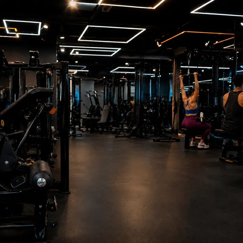 Salão de musculação da Dubai Fit com alunos treinando sob a iluminação de LED